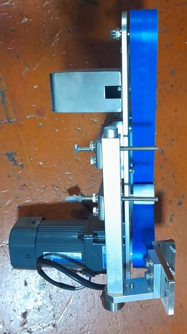 ORIENTADOR MOTORIZADO DE PRODUCTO PARA SOBREBANDA